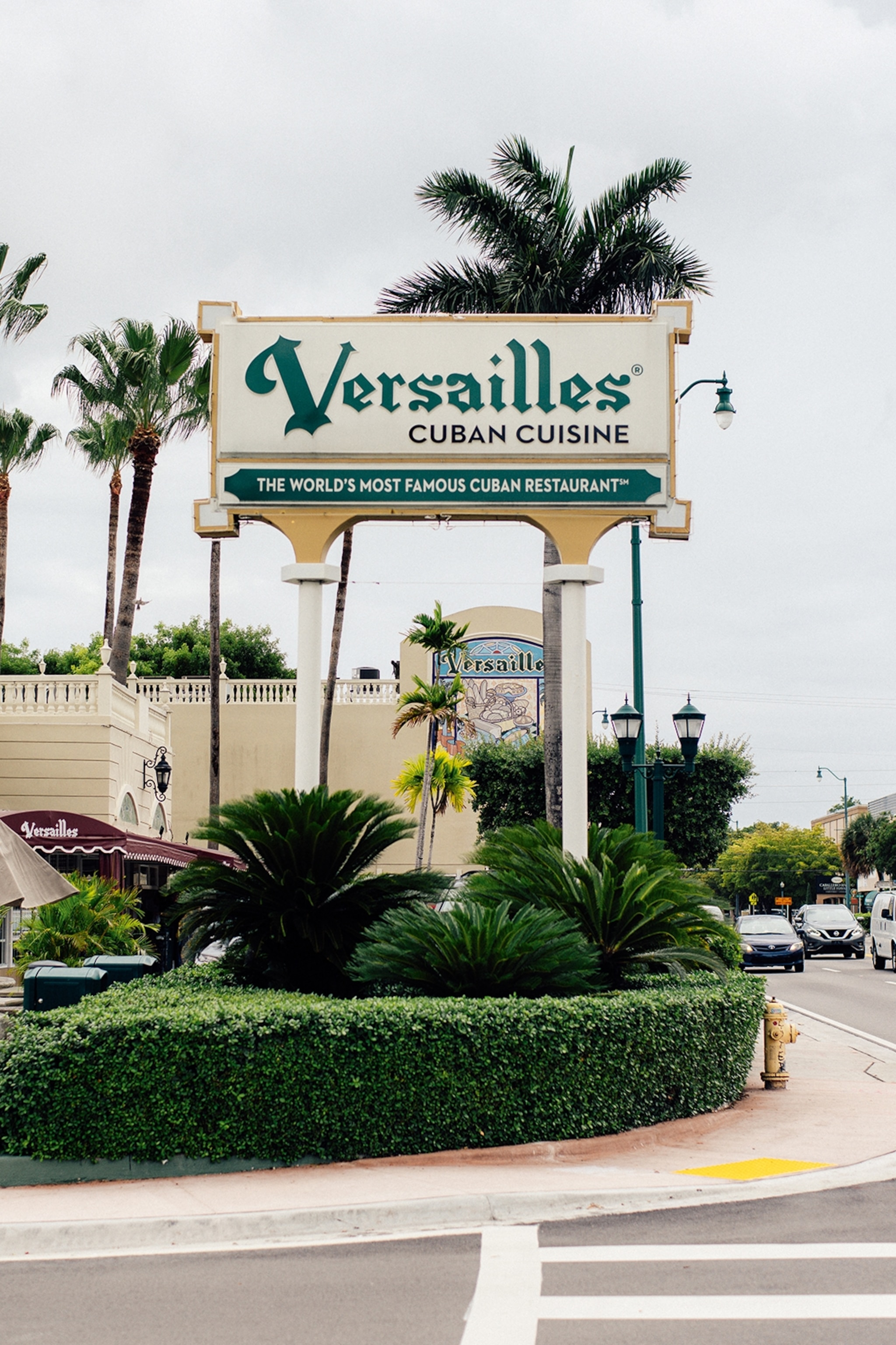 Signpost along a roadside reading 'Versailles' for a restaurant