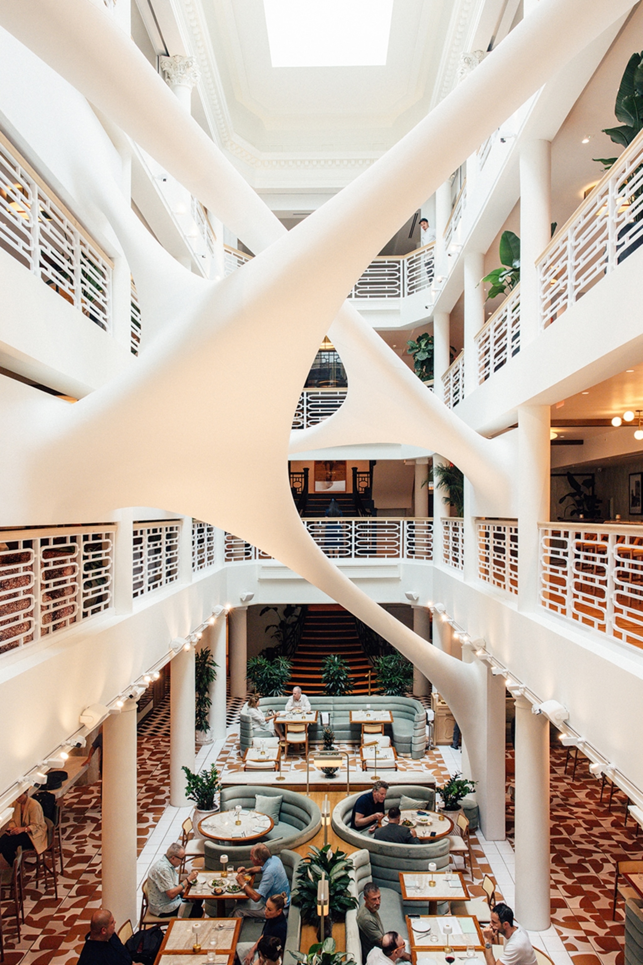 Interior of the different floors of a building with seating and tables on the bottom floor